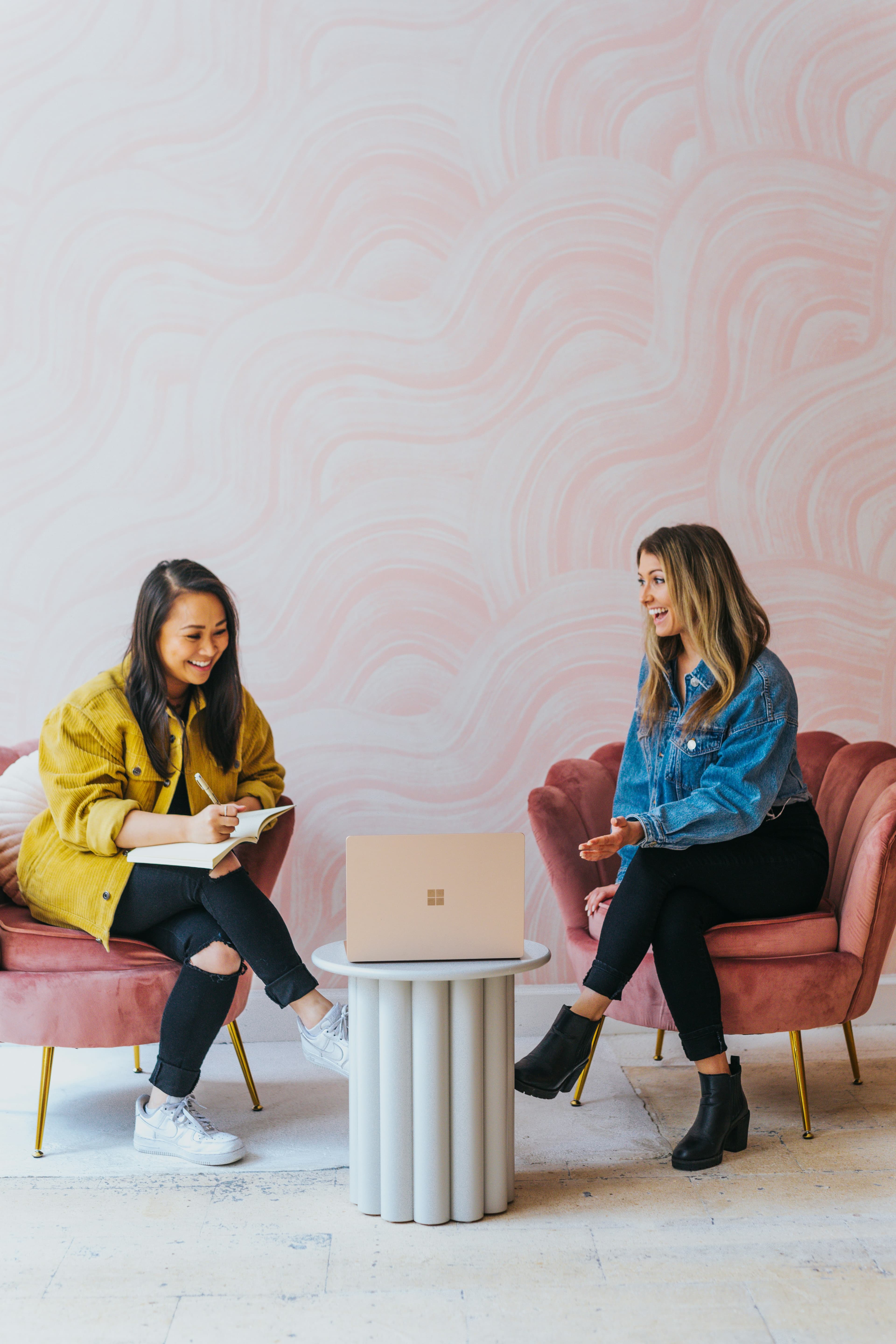 Two female founders in conversation over a laptop